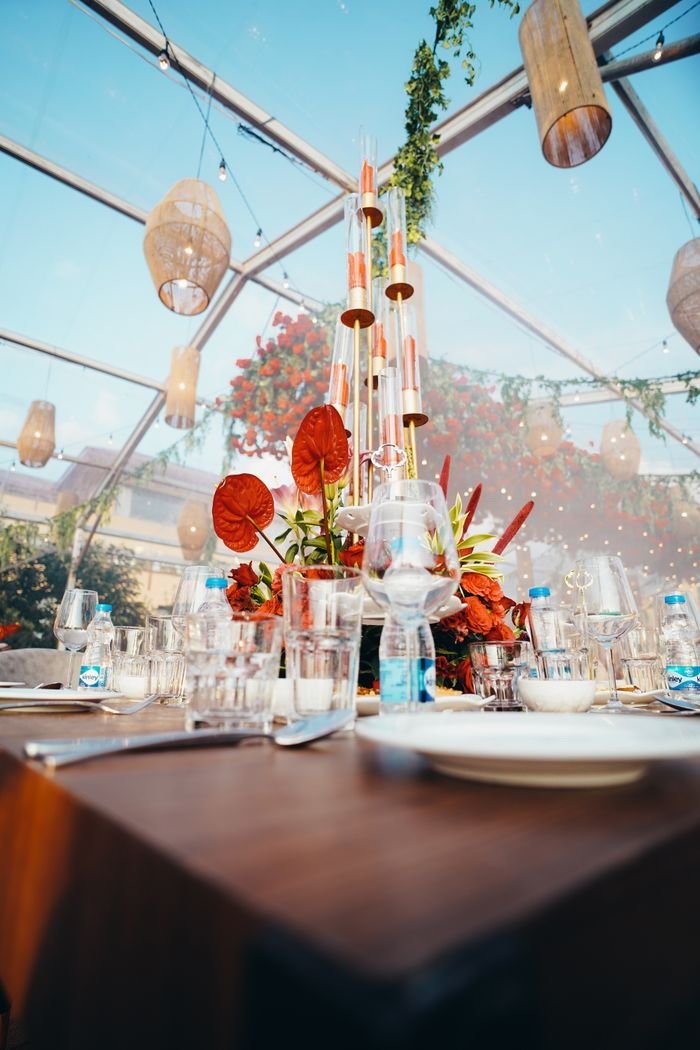 why-choose-us Elegant table setting with a floral centerpiece and candles under a glass canopy, ideal for upscale events.