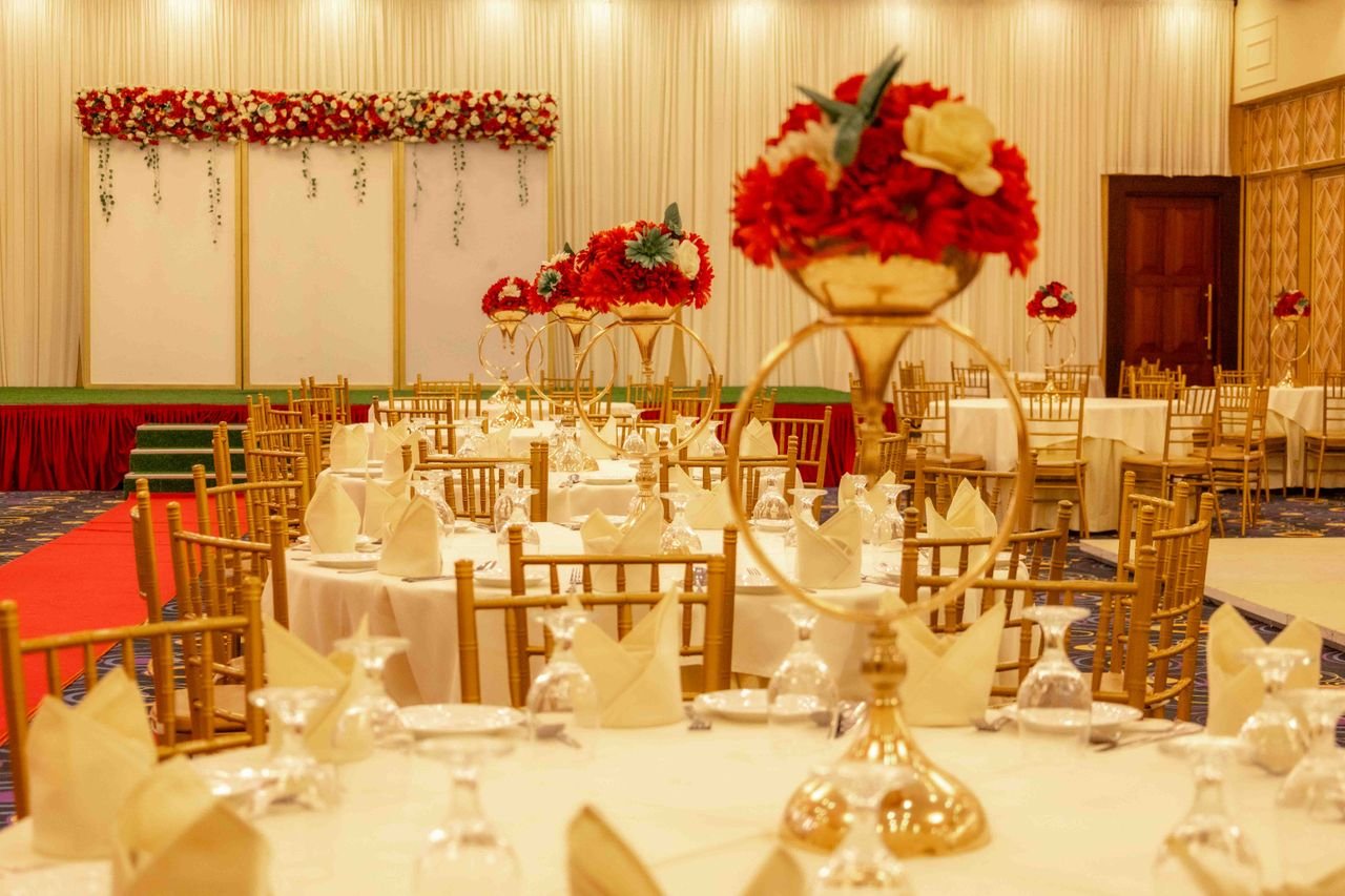 gallery-5 Luxurious wedding reception setup featuring floral centerpieces and elegant decor in banquet hall.