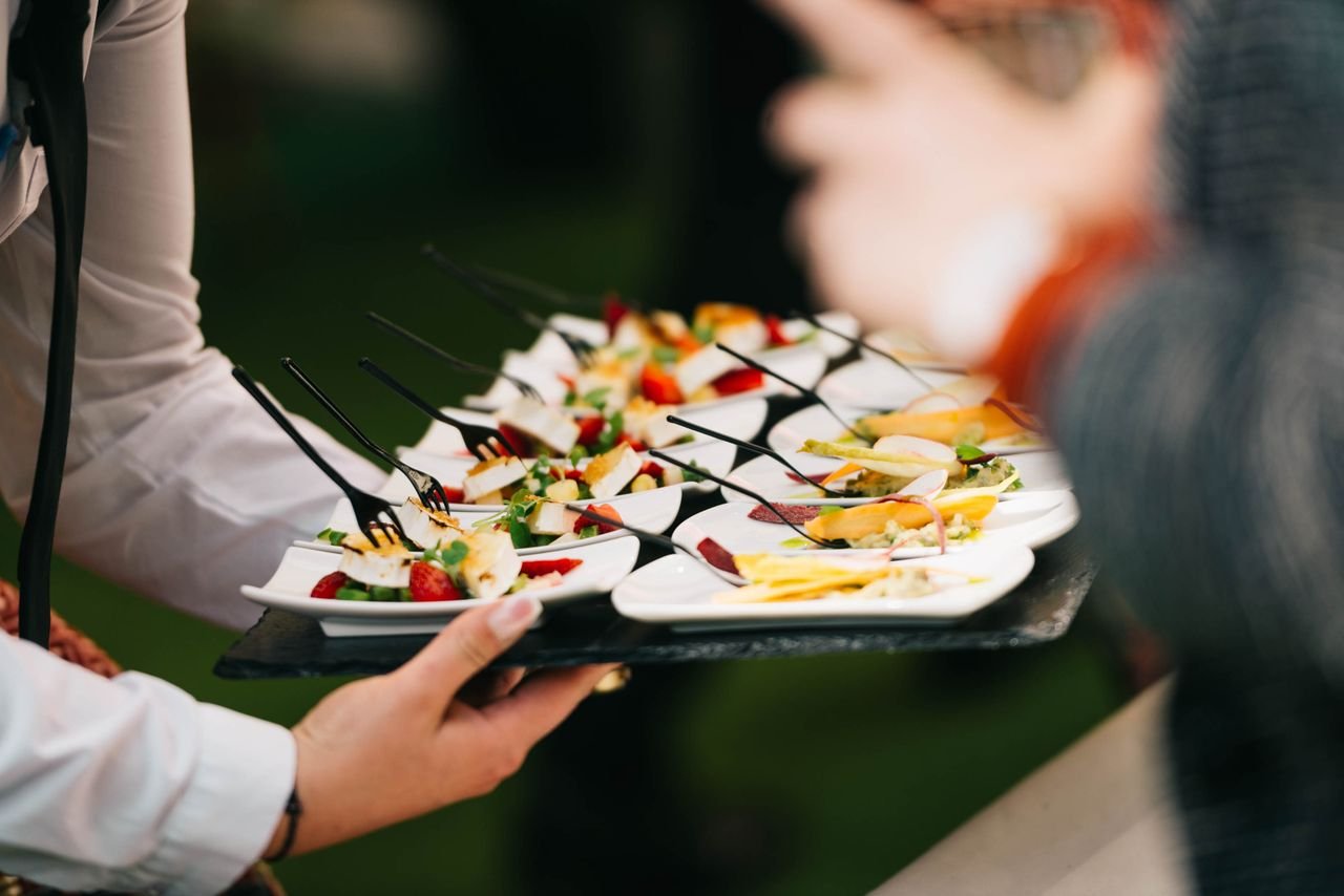 gallery-3 Elegant catering presentation with gourmet appetizers on a tray at a social event.