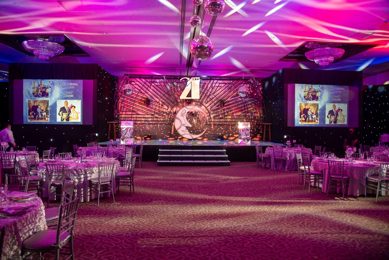 our-services-1 Vibrant event hall set up for a themed dinner with elegant decorations and lighting.