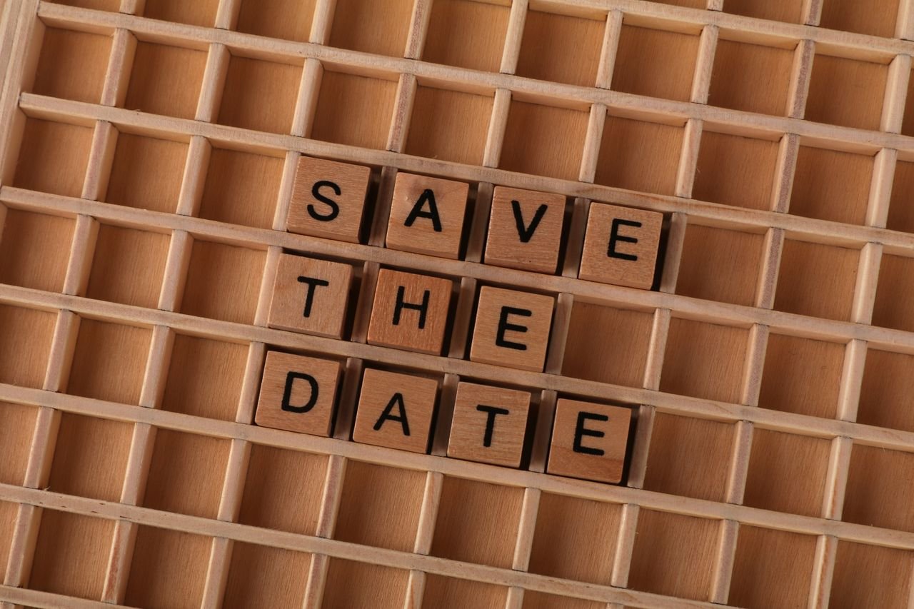 hero-img-02 "Save the Date" spelled with wooden tiles for event invitations or reminders.