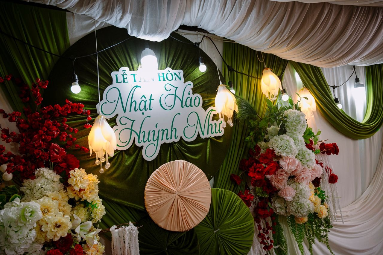 contact-img Beautiful wedding backdrop featuring lush floral arrangements and decorative lanterns in an elegant indoor setting.
